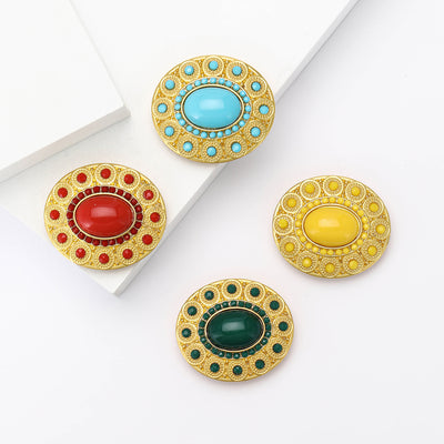 Four gold oval cabochon brooches yellow green red blue together