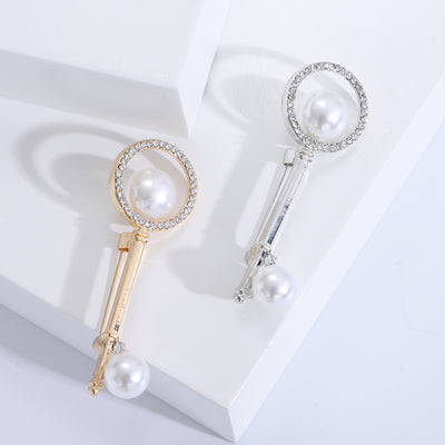 Front product view of the pearl and crystal key brooch on a light background