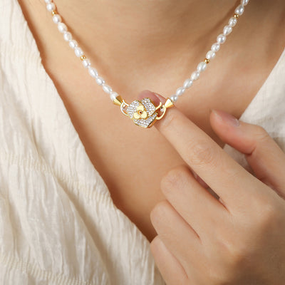 Pearl strand with gold flower pavé clasp worn and held