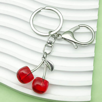 Image 1 showing a pair of red glass beads on a silver keychain.