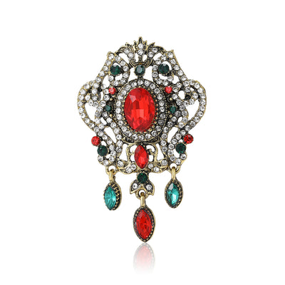 Red Baroque brooch styles arranged on a light display