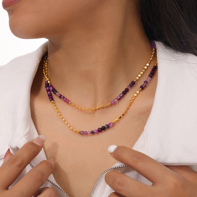 Model wearing double gold disc chains with purple agate bead stations