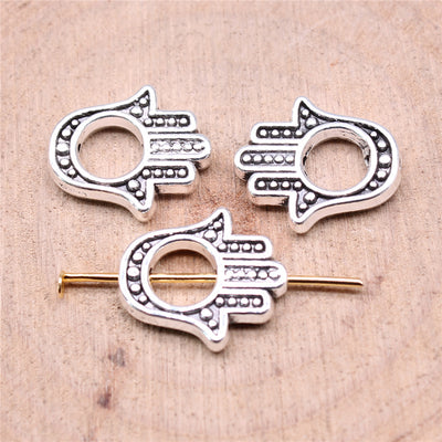 Open hamsa hand silhouette with dotted details and a central hole shown close up on a hand
