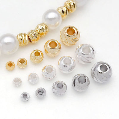 Front overview of cross fluted faceted metal spacer beads arranged by finish and size