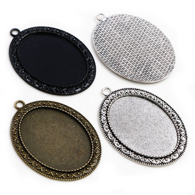 Overview of oval pendant trays with decorative borders in three finishes on a light background