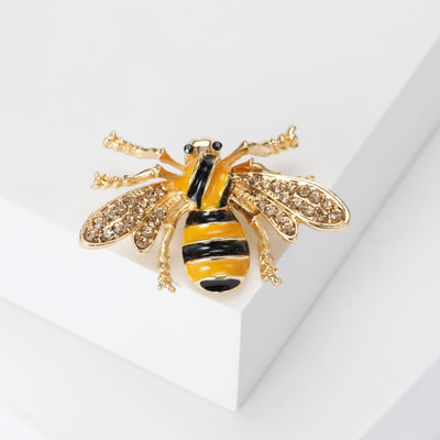 Front view of yellow and black striped bee with textured gold tone wings