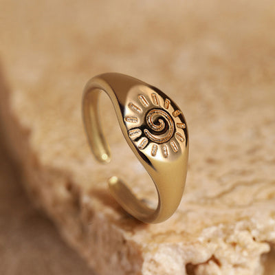 Gold sun spiral open adjustable signet ring on beige stone