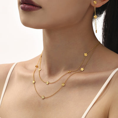 Layered gold flower station necklaces with matching drop earring on model