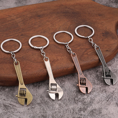 Four adjustable wrench-shaped keychains in bronze, silver, copper, and dark pewter finishes.
