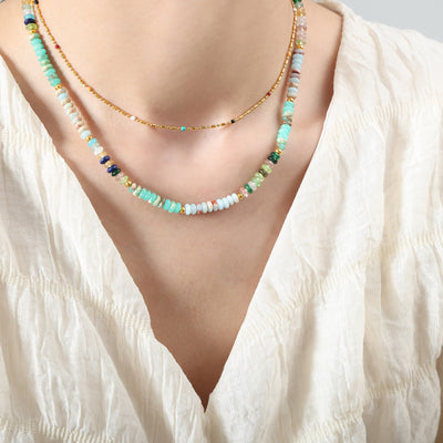 Turquoise mix disc stone bead necklace layered on model collarbone