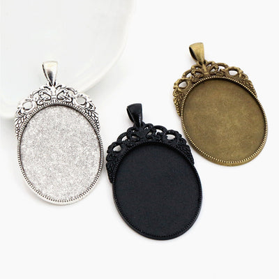 Ornate Oval Pendant Bezel Setting Trays in Three Finishes assortment on a plain background