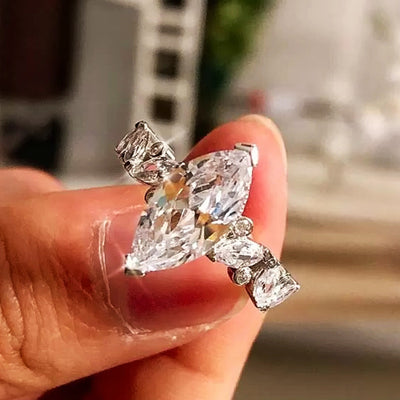 Silver marquise clear CZ ring with side stones held on fingertip