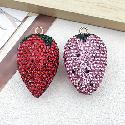 Multicolor strawberry jewelry findings arranged on a light background