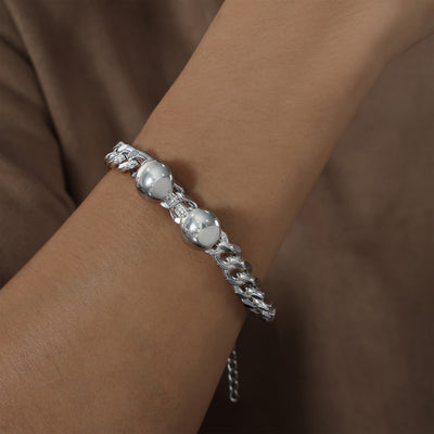 Steel cuban dual-disc bracelet worn on model wrist close-up