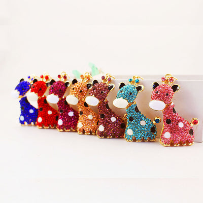 Seven rhinestone giraffe pendants in blue, red, purple, peach, aqua, and pink tones stand in a row.