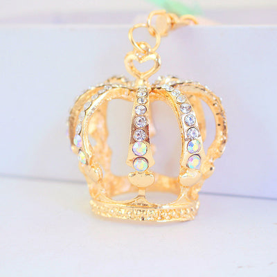 Close-up front view of a gold-tone crown charm set with clear and iridescent rhinestones.