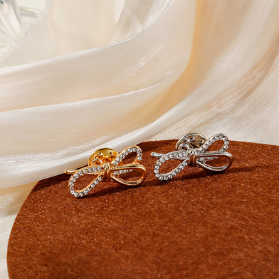 Gold and silver crystal outline bow brooches with pin backs on felt