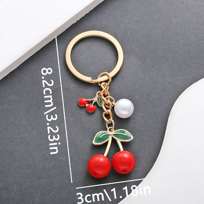Front product photo of red and black cherry pearl charm keychain showing the pictured design arrangement