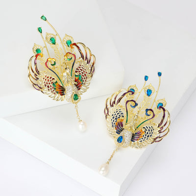 Two colorways of double phoenix crystal brooch with feather fans and pearl drop shown side by side.