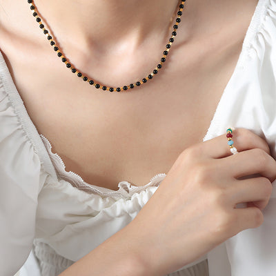 Black bead gold hexagon spacer necklace worn at collarbone