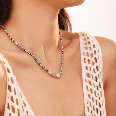 Model wearing multicolor heishi bead necklace with center pearl