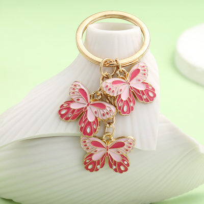 Image 1 showing a white vase with a pink butterfly keychain.