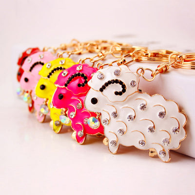 Five rhinestone sheep keychains in white, pink, hot pink, yellow, and red are arranged in a row.
