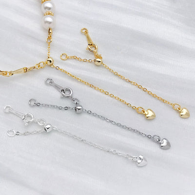 Gold-tone extender chain jewelry findings arranged on a light background