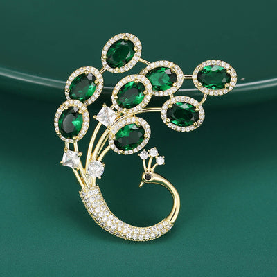 Front view of green Oval Crystal Peacock Brooch With Jeweled Fan Tail against a white background.