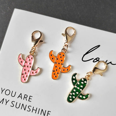 Three enamel cactus charms in pink orange and green with gold lobster clasps