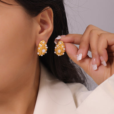 Gold teardrop pearl bead stud earring worn on ear, second held in hand