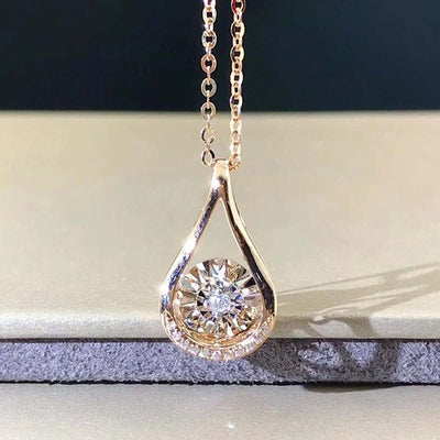 Gold teardrop open pendant with dancing clear stone
