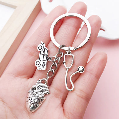 Image 1 showing a person holding a keychain with a cat and dog.