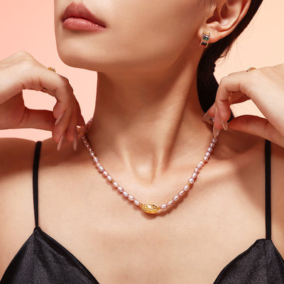 Model adjusting lavender pearl necklace with gold center bead