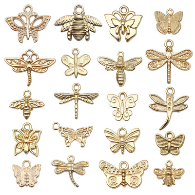 Gold-tone butterfly and dragonfly charms arranged on a light background