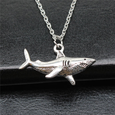 Close-up of shark pendant chain necklace showing a dimensional shark pendant on a silver-tone chain