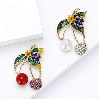 Front view of the cherry brooch with enamel leaves and crystal flowers on a white background