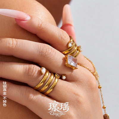 Model hand stacked gold multi band teardrop and square pearl rings