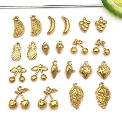 Gold-tone cherry and strawberry charms arranged on a light background