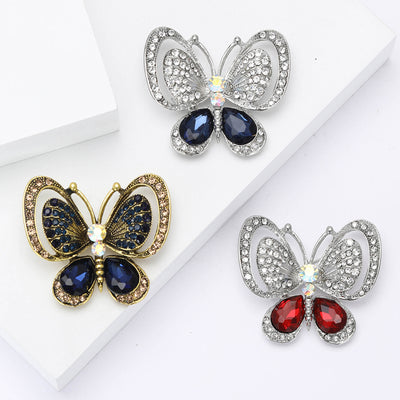 Front view of silver tone openwork butterfly with colored teardrop wing stones