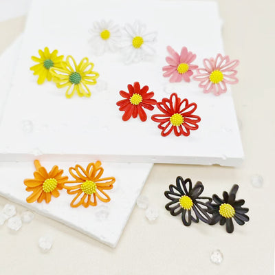 Six pairs of matte daisy flower stud earrings in yellow white pink red orange and black