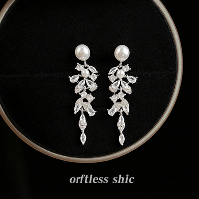 Silver pearl leaf crystal cascade drop earrings on black velvet round pad
