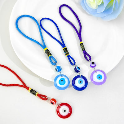 Assorted glass evil eye pendants on blue red and purple braided cords
