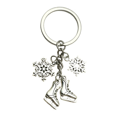 A silver-tone key ring holds two ice skate charms and two different snowflakes.