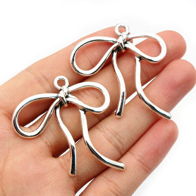 Large Antique Silver Tone Bow Pendants with Flowing Ribbon Shape — grouped product view