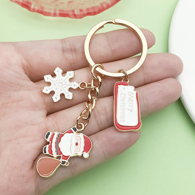 Image 1 showing a hand holding a key chain with a christmas themed design.