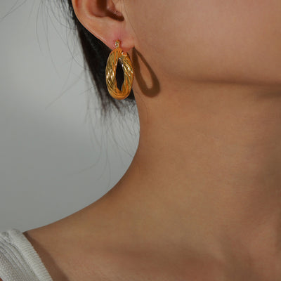 Gold twisted rope hoop worn on ear profile