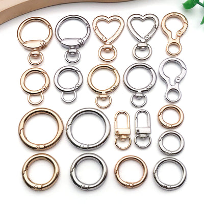 Gold-tone lobster clasp jewelry findings arranged on a light background