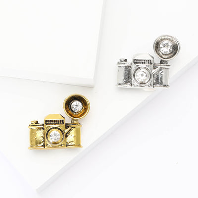 Front view showing the vintage camera brooch with round clear crystal lens