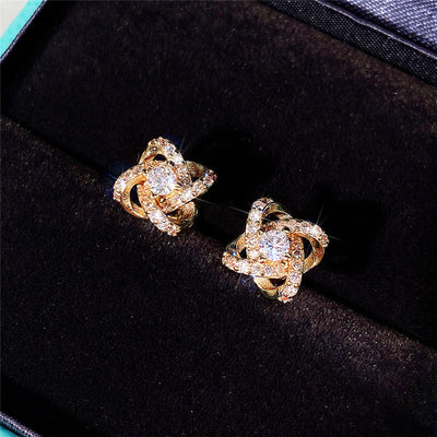 Gold flower knot clear center stud earrings on black velvet tray